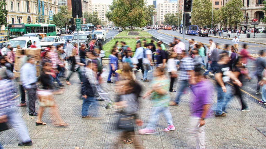 Blurred photo of people walking in busy street