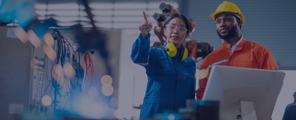Two engineers in protective workwear reviewing equipment and monitoring operations in an industrial facility.