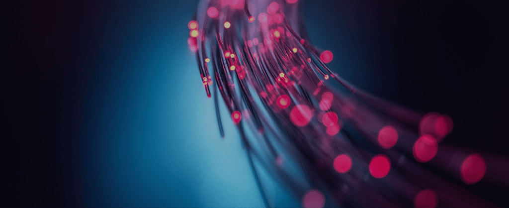 Abstract fibre optic cables with glowing pink lights against a dark blue background, representing digital connectivity and cybersecurity.