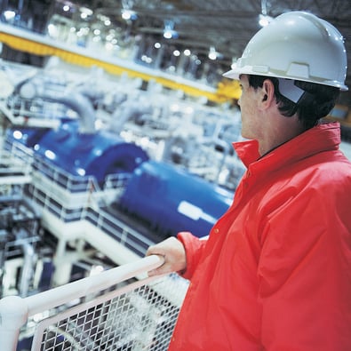 Engineer wearing hard hat overlooking the interior of a Nuclear power station