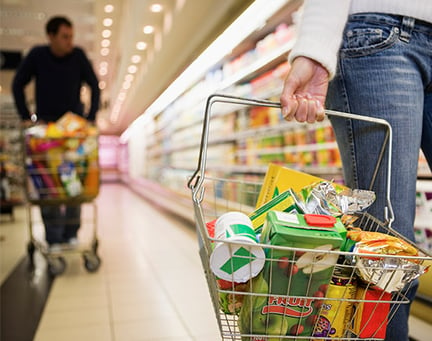 Close-up of a shopping basket in a supermarket aisle