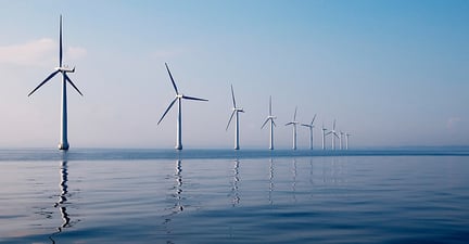 Row of wind turbines in sea, calm water