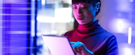 Lady focused on her ipad in a purple cyber background