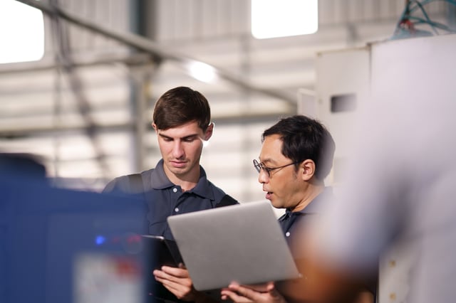 workers reviewing work on laptop